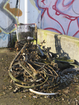 907438 Afbeelding van de uit het Merwedekanaal opgedregde restanten van fietsen en een winkelwagentje, bij de loods ...